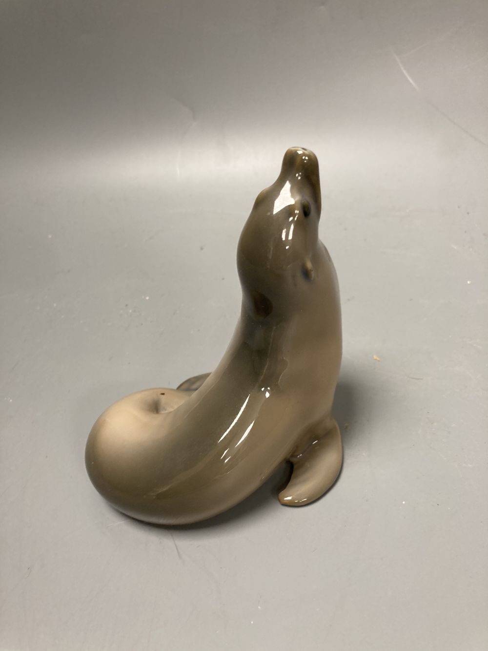 Two Lladro porcelain figures and a Royal Copenhagen model of a seal, tallest 26cm